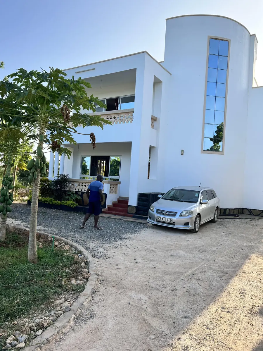 White two-storey villa with a curved glass stairwell